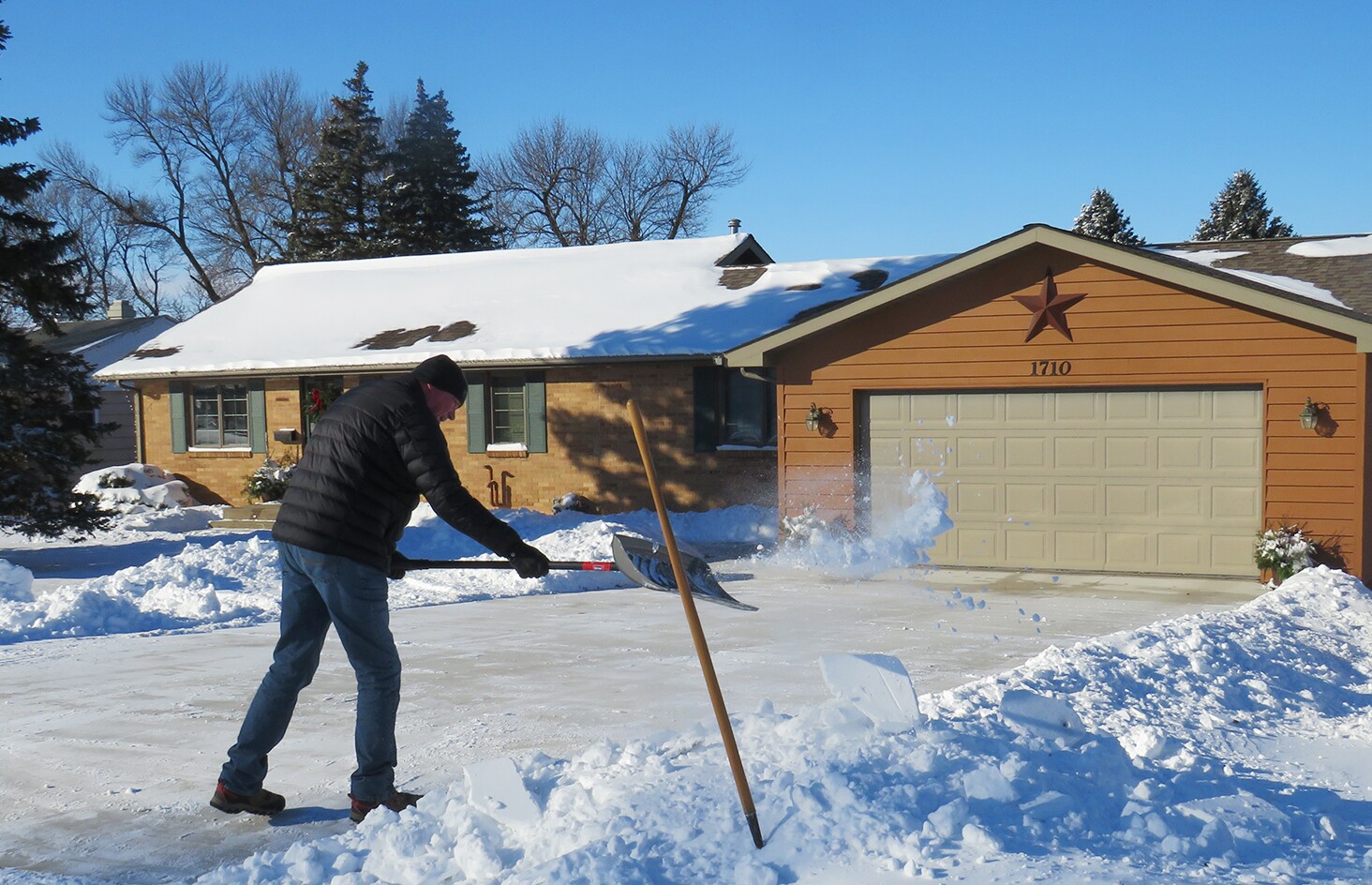 Czysty czerwony dach domu po usunięciu śniegu z widocznymi kominami i oknami