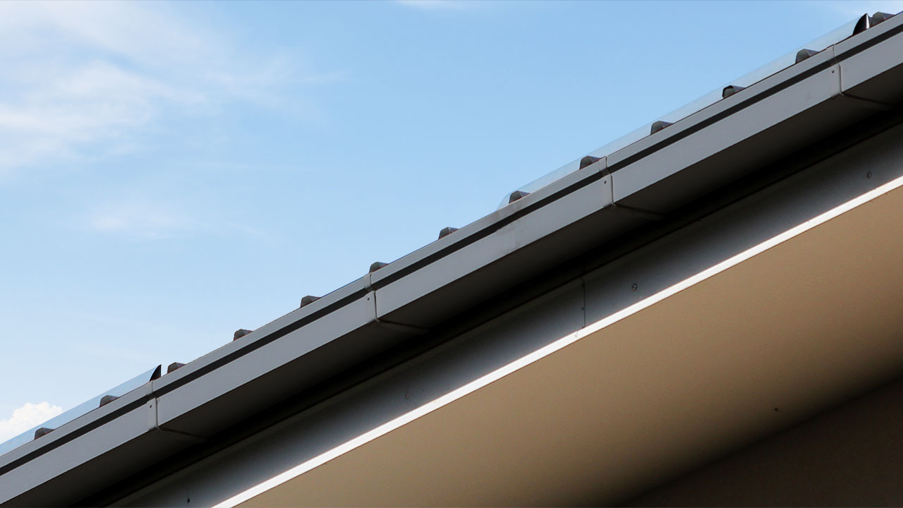 Hak rynnowy Galeco przymocowany do deski czołowej dachu z rynną